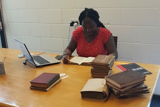 Researcher Chelsey Smith studies archive documents from Jamaica. Photo courtesy of BFSS Archives