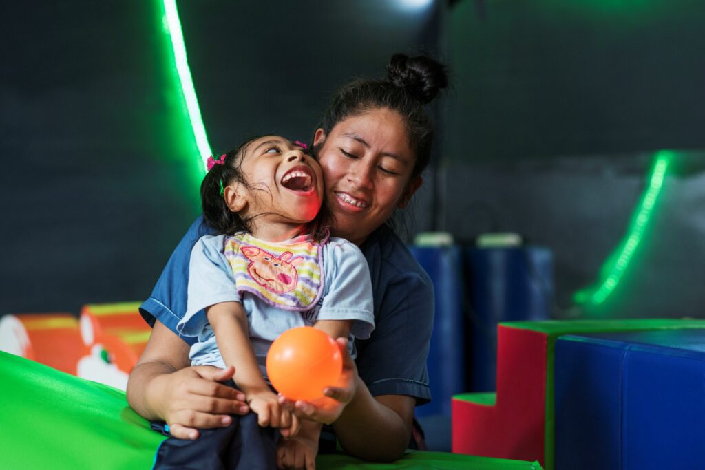 A young person and carer in a sensory room in Lima, Peru. Photo courtesy of Sense International.